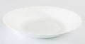 Empty white porcelain plate on white table surface Royalty Free Stock Photo