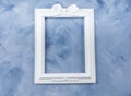 Empty white romantic picture frame on blue