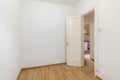 Empty white room with a front door and a view of a cozy kitchen with wooden laminate in a new apartment. Concept of Royalty Free Stock Photo