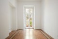 Empty, white room with large window in a renovated apartment