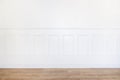 Empty white room with parquet floor and wood trimmed wall