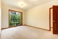 Empty white room with wood door and beige carpet. Royalty Free Stock Photo