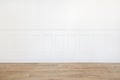 Empty white room with wooden floor and wood trimmed wall