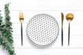 Empty white round plate with black peas, fork, knife, spoon, sprig of eucalyptus on wooden table Top view Flat lay Dishes for Royalty Free Stock Photo