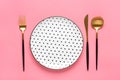 Empty white round plate with black peas, fork, knife, spoon on trendy pink background Top view Flat lay Dishes for breakfast, Royalty Free Stock Photo