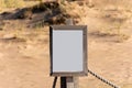 Empty white sign with partly broken wooden frame on a sandy beach Royalty Free Stock Photo