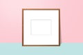 Empty white space in wooden blank frame leaning against with pink wall