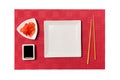 Empty white square plate with chopsticks for sushi and soy sauce, ginger on red mat sushi background. Top view with copy space for Royalty Free Stock Photo