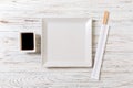 Empty white square plate with chopsticks for sushi and soy sauce on wooden background. Top view with copy space Royalty Free Stock Photo