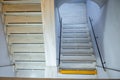 An empty white staircase in an old building with a single yellow caution step