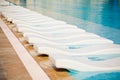 Empty white sunbeds near swimming pool Royalty Free Stock Photo