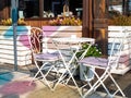 Empty white table and couple chairs on street outside a cafe bar or restaurant