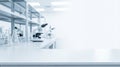 Empty white table top in science laboratory with blurred microscope and glassware. Medical research background for product display Royalty Free Stock Photo