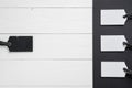 Empty white tags in a row on white and black wooden background. Top view. Mock up sample. Blank price tag on wooden planks. Design Royalty Free Stock Photo