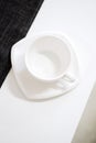 Empty white tea cup and saucer on the table. Porcelain dishes, selective focus