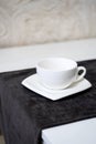 Empty white tea cup and saucer on the table. Porcelain dishes, selective focus