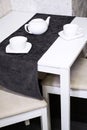 Empty white tea set, cup, saucer and teapot on the table. Porcelain dishes, selective focus