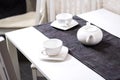 Empty white tea set, cup, saucer and teapot on the table. Porcelain dishes, selective focus