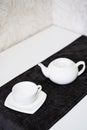 Empty white tea set, cup, saucer and teapot on the table. Porcelain dishes, selective focus