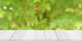 Empty white wood table top with blur green bokeh background Royalty Free Stock Photo