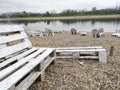 Empty white wooden benches on beach at lake Ada Ciganlija, Belgrade, Serbia. Royalty Free Stock Photo