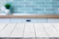 Empty white wooden boards or table top over blurred kitchen interior on background. Template, mockup for display or Royalty Free Stock Photo