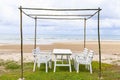 White wooden dining table for four on the beachfront lawn