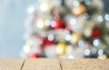 Empty white wooden table and blurred fir tree with Christmas lights on background. Space for design Royalty Free Stock Photo