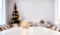 Empty white wooden table top with defocused modern dinning room and Christmas tree in the background for design