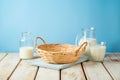 Empty wicker basket with tablecloth and milk bottles on rustic table over blue wall  background.  Kitchen mock up for design and Royalty Free Stock Photo