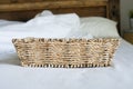 Empty Wicker basket on a white bed.