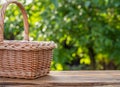 The empty wicker basket on the wooden table, green nature at the background Royalty Free Stock Photo
