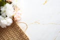 Empty wicker tray and bouquet of flowers on marble background. Top view Royalty Free Stock Photo