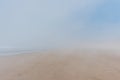 Empty wide sandy ocean beach in fog