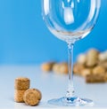 An empty wine glass on a blue background stands on a white table. Corks from wine bottles close-up. Tasting expensive Royalty Free Stock Photo