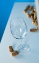 An empty wine glass on a blue background stands on a white table. Corks from wine bottles. Tasting expensive wine. Royalty Free Stock Photo