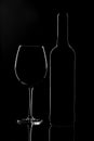 Empty wine glass and a bottle isolated on a dark background Royalty Free Stock Photo