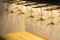 Empty wine glasses hanging on bar rack