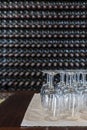 Empty wine glasses with many  stacked bottles as a background - preparation to wine tasting in winery, Lanzarote, Spain Royalty Free Stock Photo