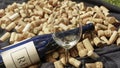 Empty wineglass on the defocused or bokhe background of wine bottle and corks. Wine concept. Space for text Royalty Free Stock Photo