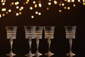 Empty wineglasses on mirror surface against dark background with blurred lights. Bokeh effect Royalty Free Stock Photo