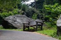 Empty Wood Bench on a Trail with Green Plants and Large Stones during Summer in Central Park of New York City Royalty Free Stock Photo