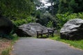 Empty Wood Bench on a Trail with Green Plants and Large Stones during Summer in Central Park of New York City Royalty Free Stock Photo