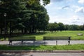 Empty Wood Benches and a Green Grass Field at Flushing Meadows Corona Park in Queens of New York City during Summer Royalty Free Stock Photo