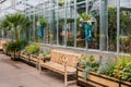 Empty Wood Benches by Greenhouse in Garden