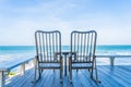 Empty wood chair and table at outdoor patio with beautiful tropical beach and sea Royalty Free Stock Photo