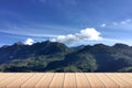 Empty wood plank table top with big green Mountian and clouds with blur background - For product display. Royalty Free Stock Photo