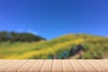 Empty wood plank table top with yellow flower field , mountain and blue sky blurred background. For product display. Royalty Free Stock Photo