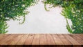 Empty wood table with ivy leaves on cement wall background Royalty Free Stock Photo