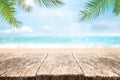 Empty wood table over sea, beach and palm leaves background in summer day. Background with copy space for product display Royalty Free Stock Photo